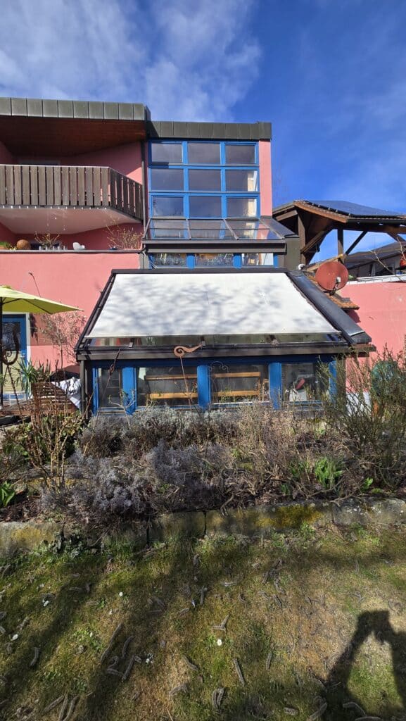 efektes Markisentuch einer Wintergartenbeschattung auf einem roten Wohnhaus.